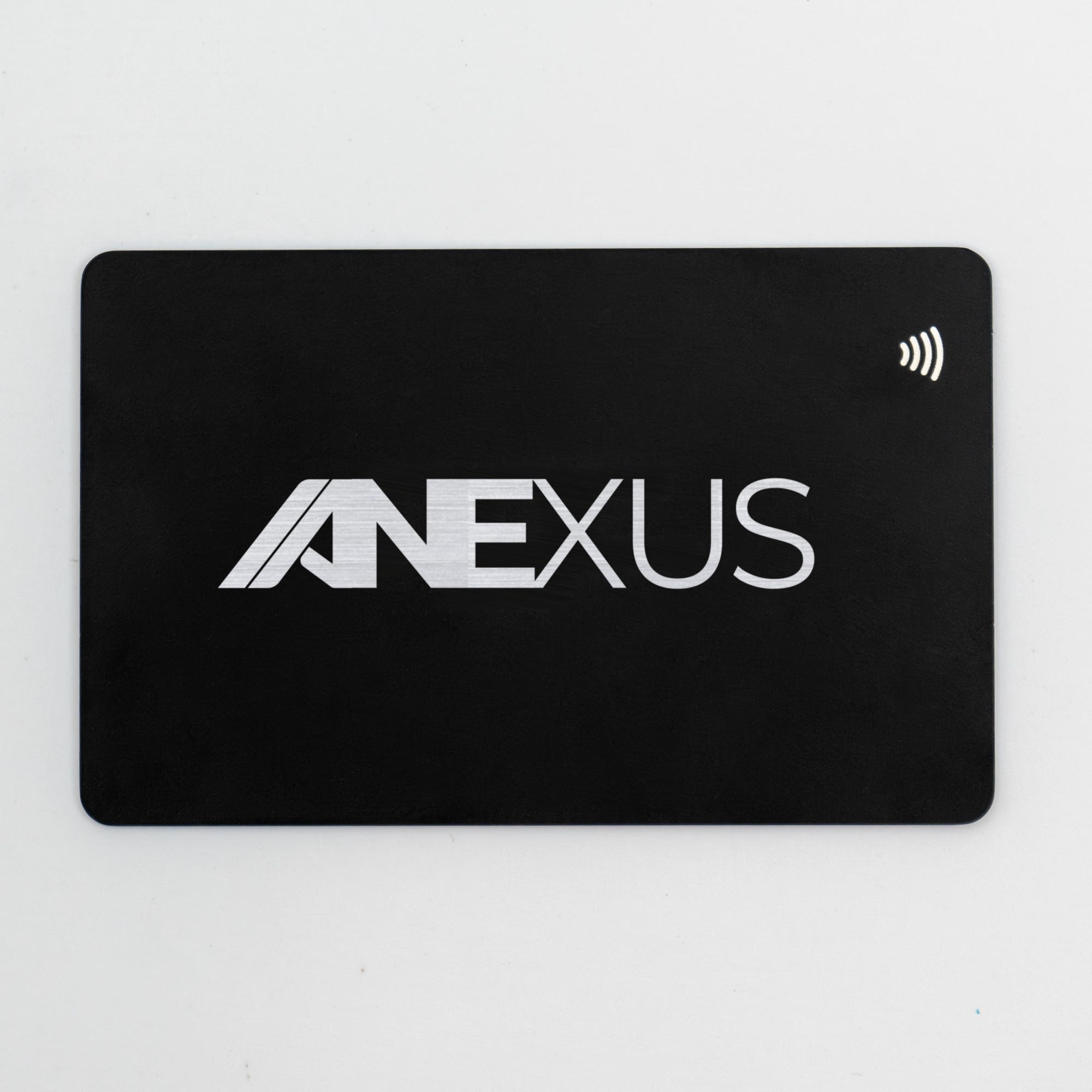 The face of a black metal Anexus NFC business card, shown flat