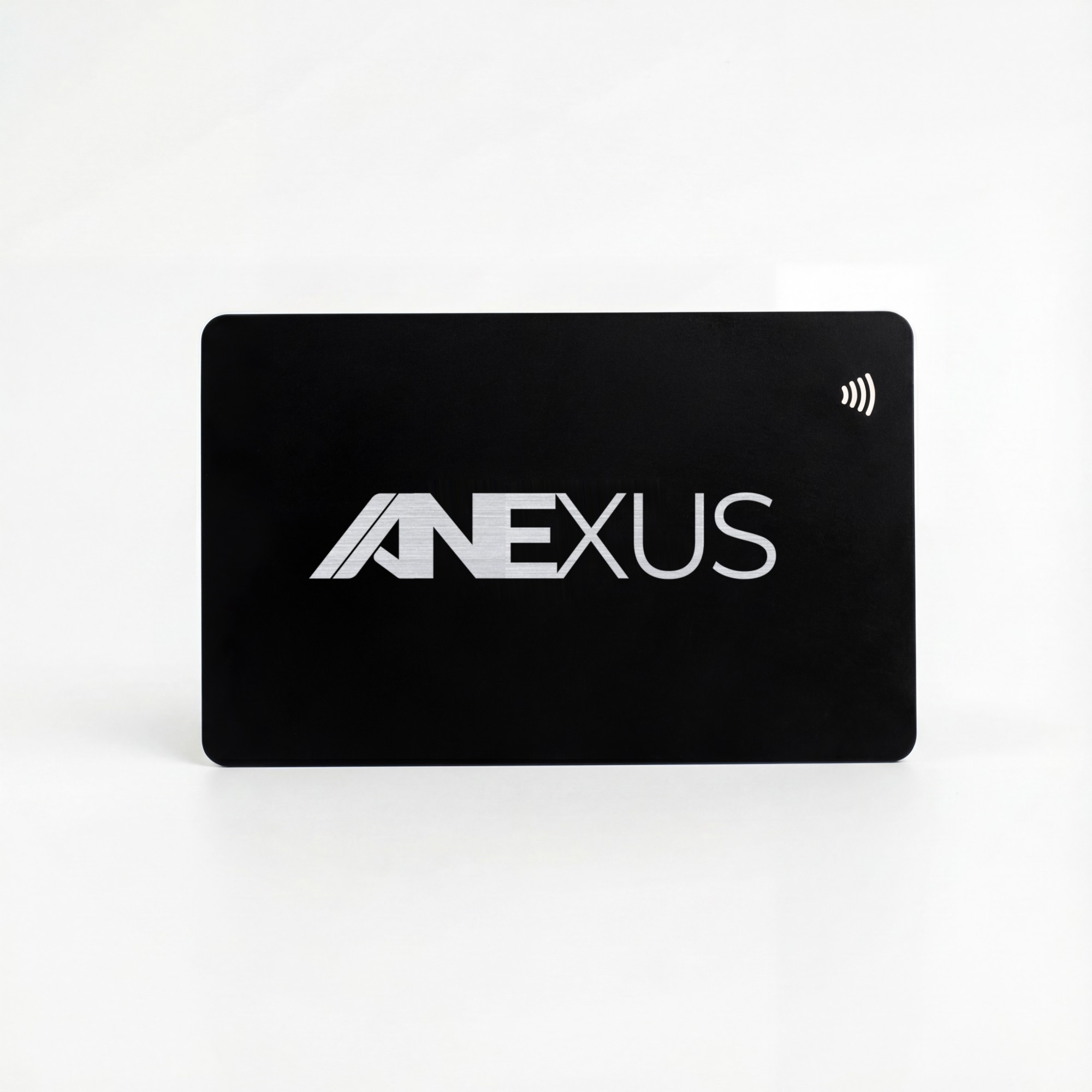 Une carte de visite NFC Anexus en métal noir, debout sur une surface blanche